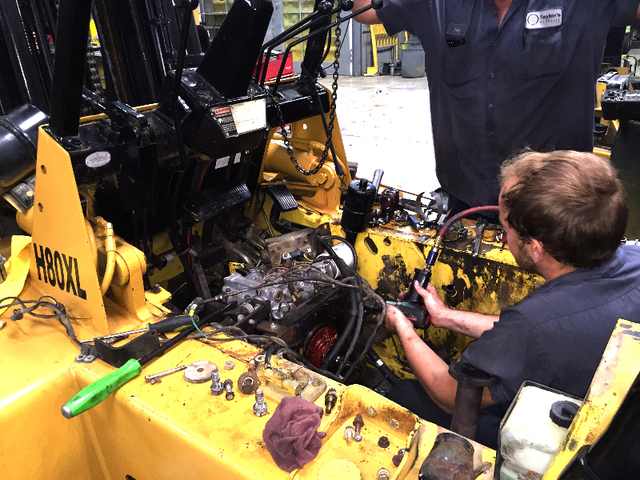 Man Repairing Forklift